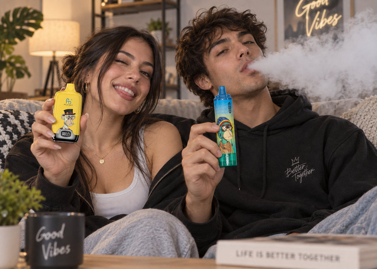 Paar auf dem Sofa hält zwei Fumot Vapes mit Display und Akkuanzeige
